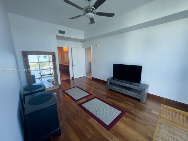 living room featuring ceiling fan and dark wood-type flooring