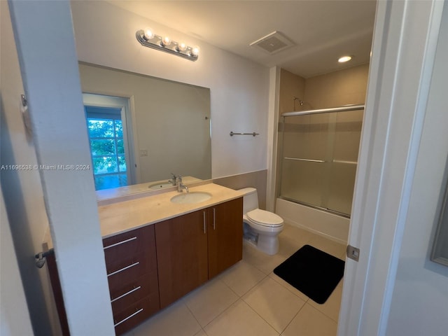 full bathroom with tile patterned floors, shower / bath combination with glass door, vanity, and toilet