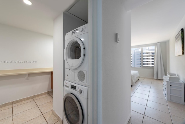 laundry room with stacked washing maching and dryer and light tile patterned flooring