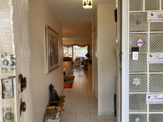 hallway featuring light tile patterned floors and a textured ceiling