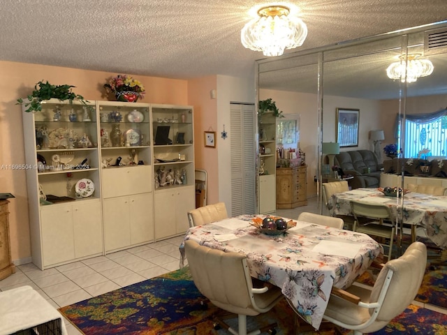 tiled dining room featuring a textured ceiling and a notable chandelier