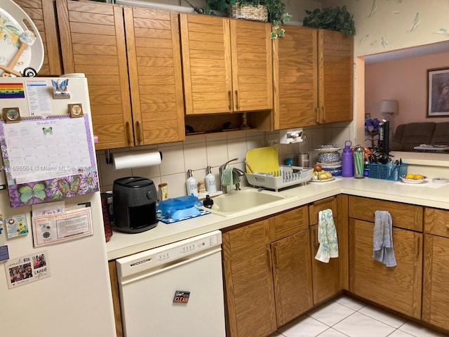 kitchen with backsplash, white appliances, sink, and light tile patterned floors