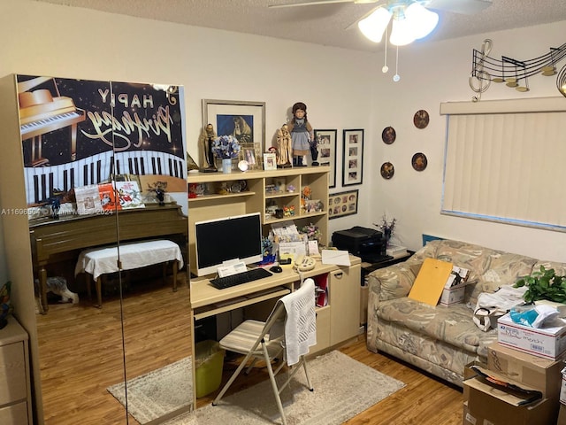 home office featuring a textured ceiling, hardwood / wood-style flooring, and ceiling fan