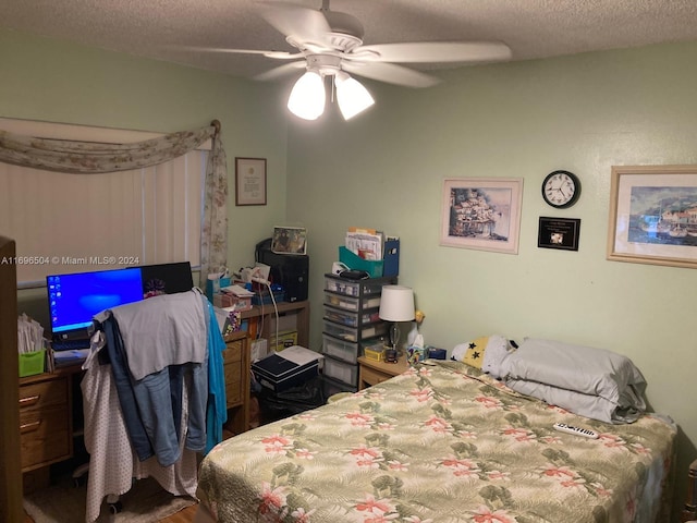 bedroom with ceiling fan and a textured ceiling