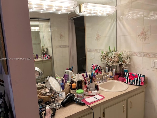 bathroom featuring vanity and tile walls