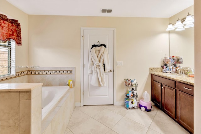 bathroom with tiled bath, tile patterned flooring, and vanity