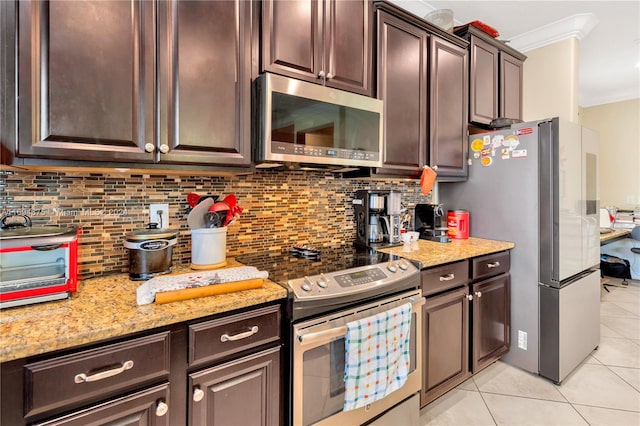 kitchen with light stone countertops, appliances with stainless steel finishes, dark brown cabinets, light tile patterned floors, and ornamental molding