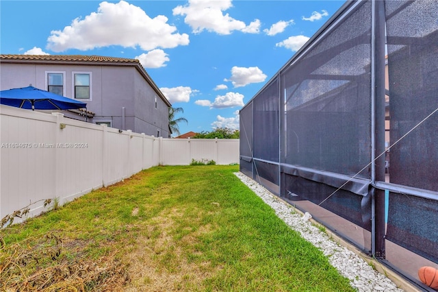 view of yard with glass enclosure