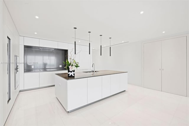 kitchen with white cabinetry, modern cabinets, an island with sink, and a sink