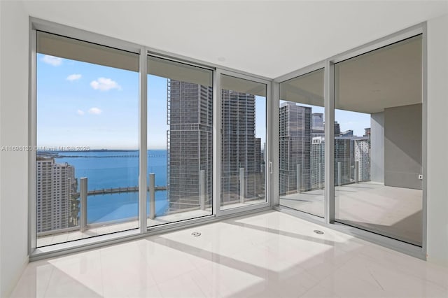 unfurnished room featuring tile patterned floors and a water view