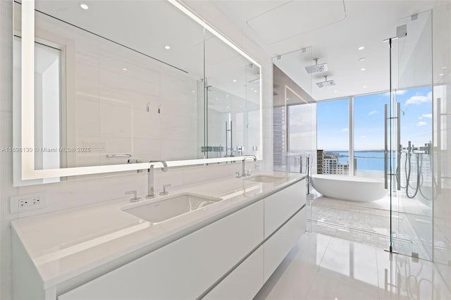 full bath with double vanity, a sink, a shower stall, and a water view