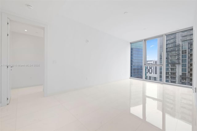 spare room featuring expansive windows and tile patterned floors