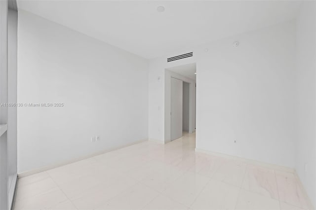 spare room featuring visible vents and baseboards
