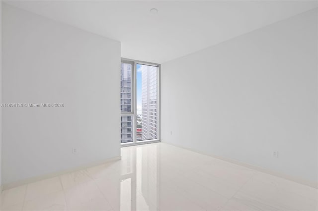 spare room featuring a wall of windows and a city view