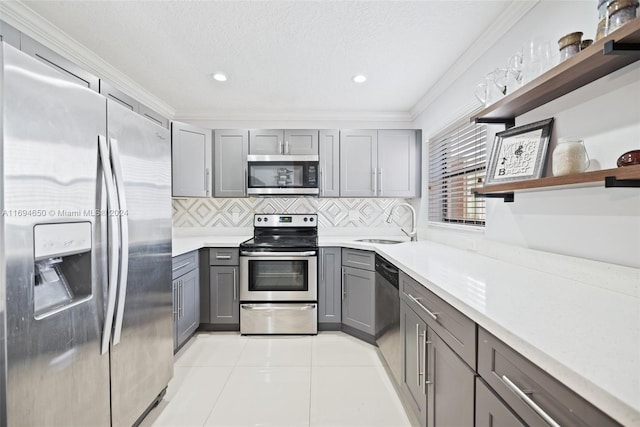 kitchen featuring gray cabinets, sink, ornamental molding, and appliances with stainless steel finishes