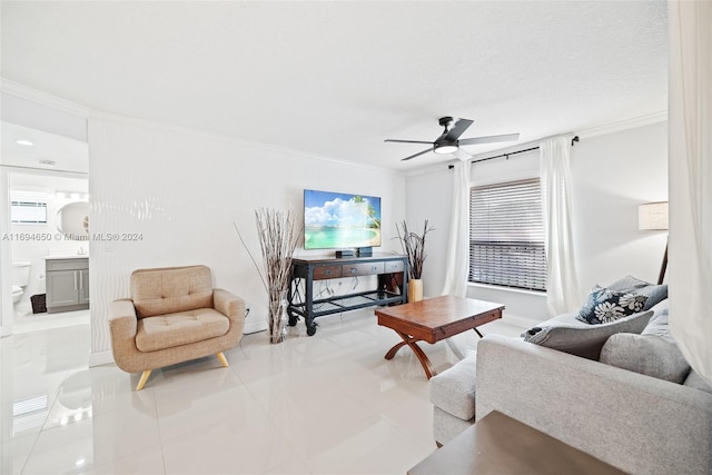 tiled living room with ceiling fan and crown molding