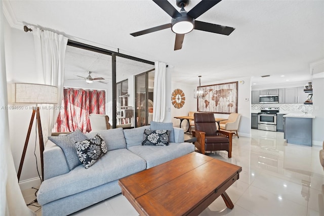 living room featuring light tile patterned floors and ceiling fan with notable chandelier