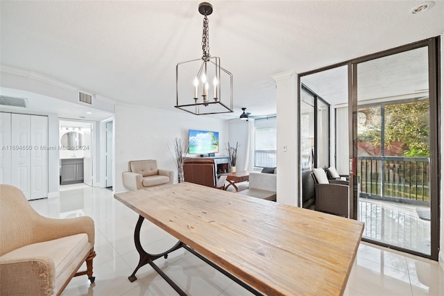 dining room with light tile patterned floors, ceiling fan with notable chandelier, and ornamental molding