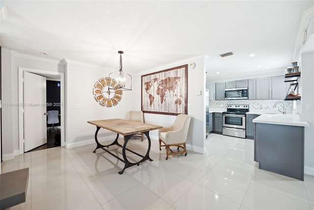 dining room with a chandelier, sink, crown molding, and light tile patterned flooring