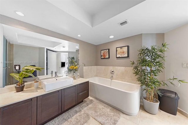 bathroom with tile patterned floors, vanity, and a tub