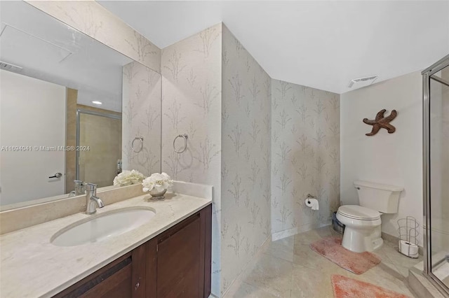 bathroom featuring tile patterned flooring, vanity, toilet, and walk in shower