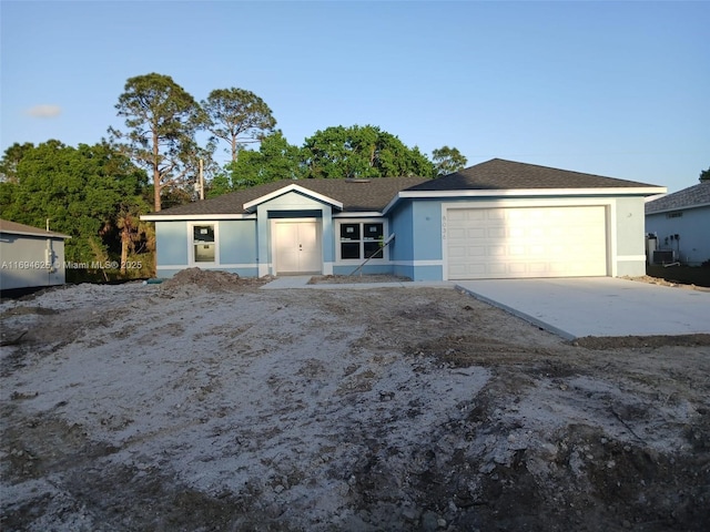 ranch-style house featuring an attached garage, concrete driveway, and stucco siding