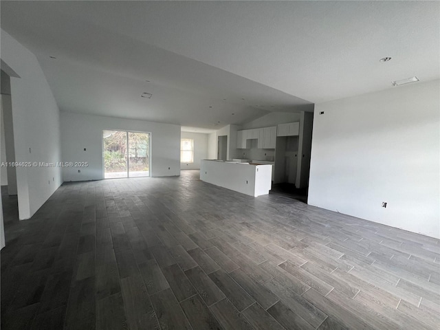 unfurnished living room featuring vaulted ceiling and hardwood / wood-style floors