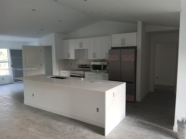 kitchen featuring vaulted ceiling, stainless steel appliances, a large island, and white cabinets