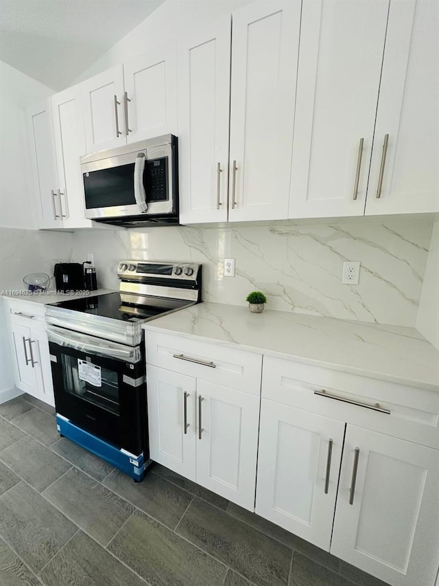 8036 104th Ct, Vero Beach, FL 32967 - kitchen featuring stainless steel appliances, white cabinetry, light stone counters, and backsplash
