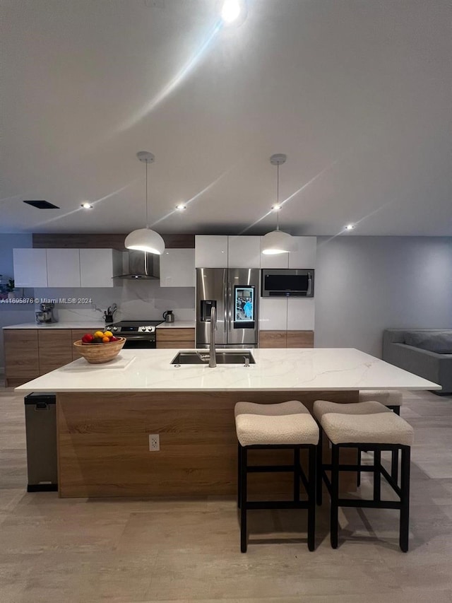 kitchen with sink, decorative light fixtures, a spacious island, and stainless steel appliances