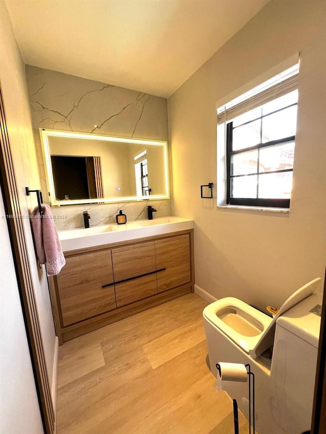 bathroom with hardwood / wood-style floors, vanity, and toilet