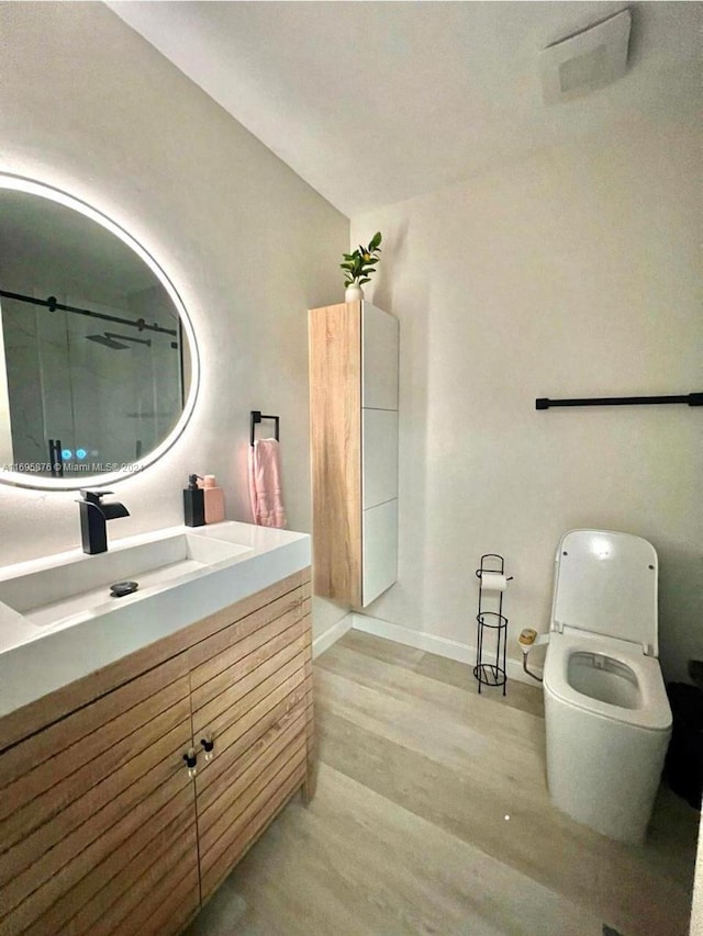 bathroom featuring vanity, hardwood / wood-style flooring, and toilet