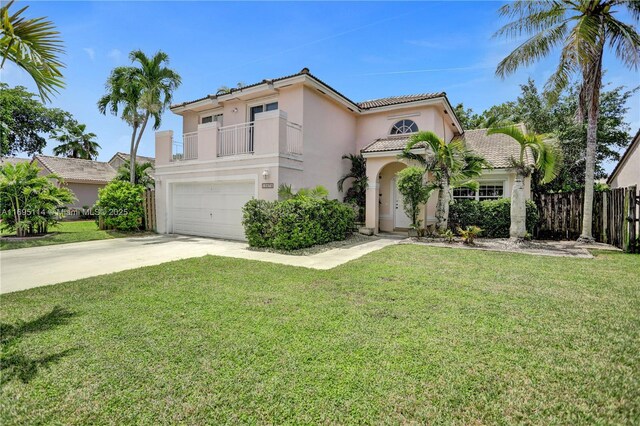 mediterranean / spanish house with a front yard, a balcony, and a garage