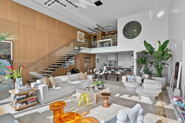 living room featuring a chandelier, a towering ceiling, and hardwood / wood-style flooring