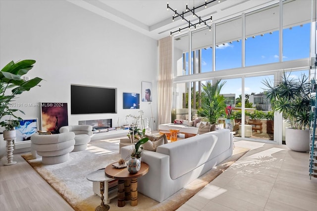 tiled living room with a towering ceiling and a notable chandelier