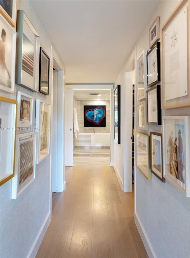 corridor with light hardwood / wood-style floors