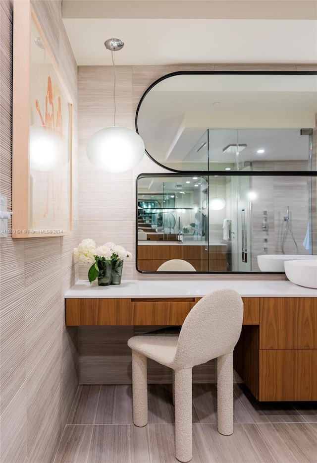 bathroom with vanity, an enclosed shower, and tile walls