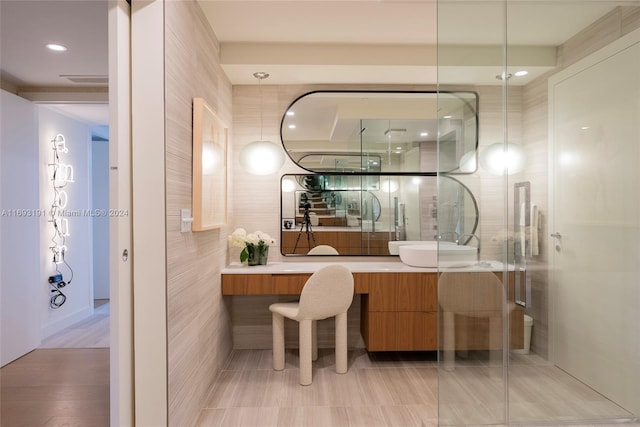 bathroom featuring hardwood / wood-style floors, vanity, an enclosed shower, and tile walls