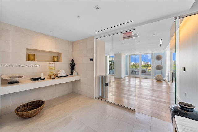 interior space featuring expansive windows, wood-type flooring, and tile walls