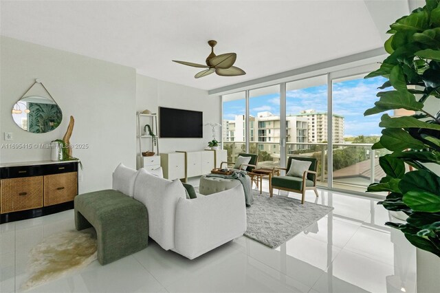 tiled living room with ceiling fan and floor to ceiling windows