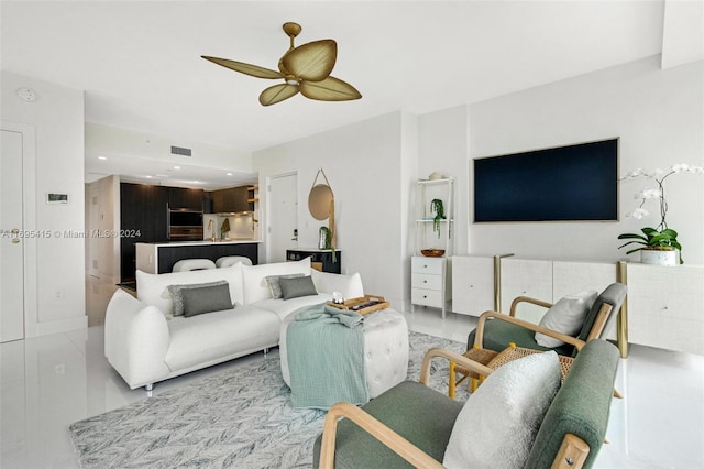 living room featuring ceiling fan, light tile patterned floors, and sink