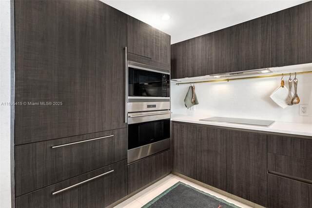 kitchen with backsplash, light tile patterned floors, and appliances with stainless steel finishes