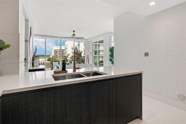 kitchen featuring kitchen peninsula, ceiling fan, sink, and light tile patterned floors