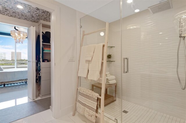 bathroom with a chandelier, tile patterned floors, and an enclosed shower