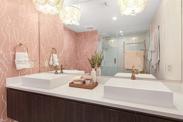 bathroom with a notable chandelier, an enclosed shower, and vanity