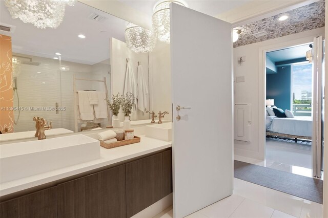 bathroom with tile patterned flooring, vanity, a shower with door, and a notable chandelier