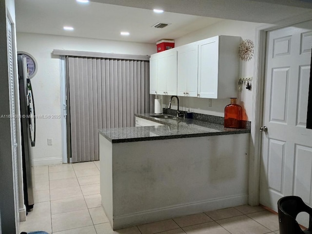 kitchen with white cabinetry, sink, light tile patterned floors, and kitchen peninsula