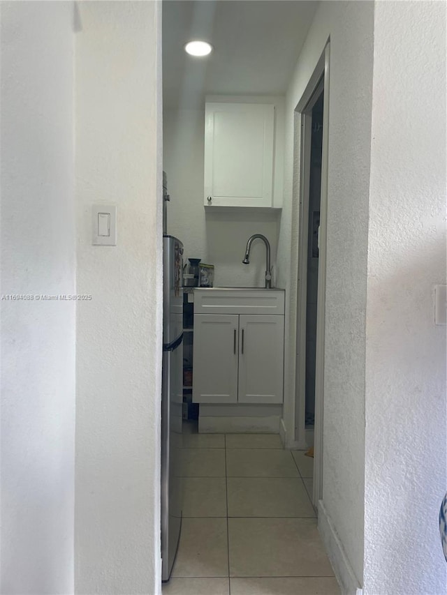 hall with light tile patterned flooring and sink