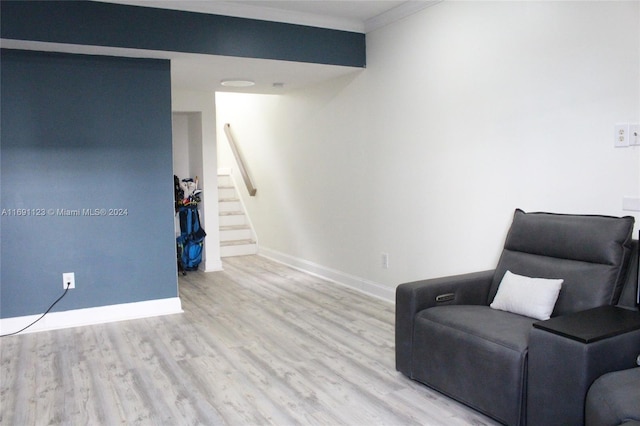 living area featuring crown molding and light wood-type flooring