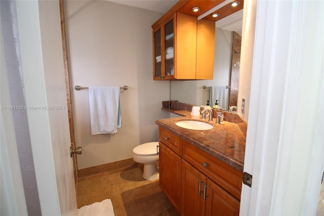 bathroom with tile patterned flooring, vanity, and toilet